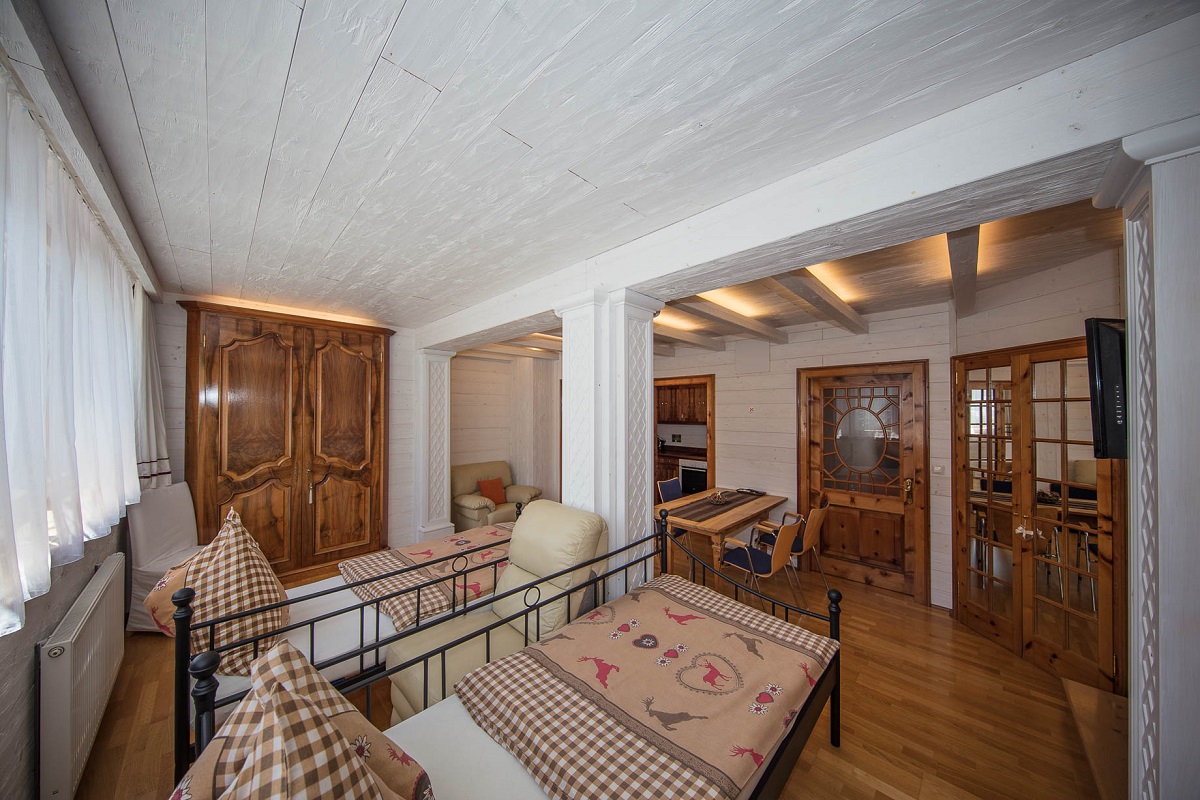 Schlafzimmer mit Tisch und Einbauküche - Tirolerhaus